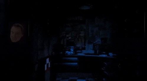 a person is standing in a dark room with a light shining on them .