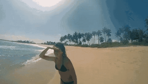 a woman in a bikini is standing on a beach