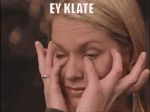 a woman is covering her eyes with her hands and the words ey klate are written above her .