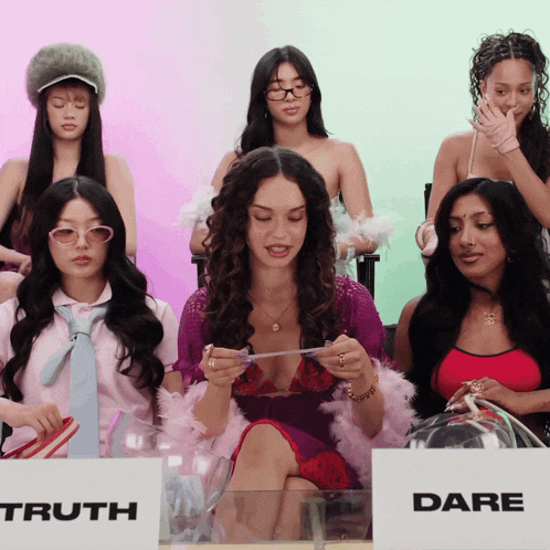 a group of women sitting around a table with a sign that says truth and dare