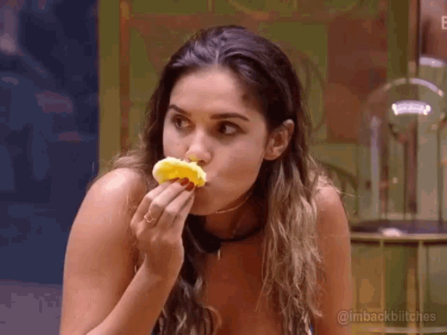 a woman is eating a piece of food in a room .