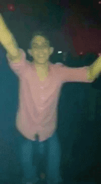 a pixelated image of a man in a purple shirt dancing