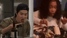 a man and a woman are sitting at a table eating .