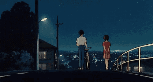 a man riding a bike stands next to a woman in a red shirt