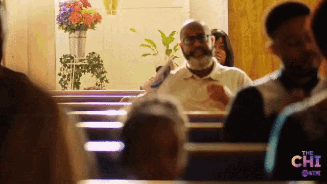a group of people in a church with the chi showtime logo
