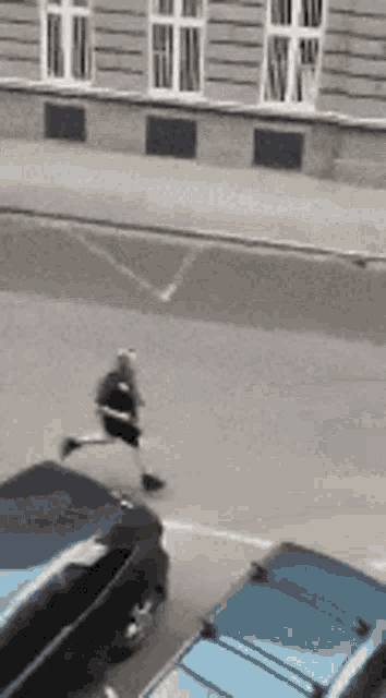 a black and white photo of a person running on a street