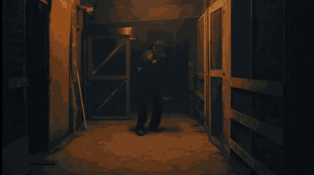 a man standing in a dark hallway wearing a shirt that says ' skeletons ' on it