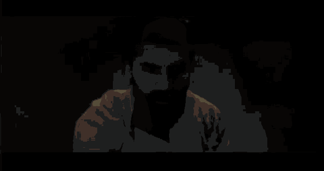 a young man with curly hair is standing in a dark room .