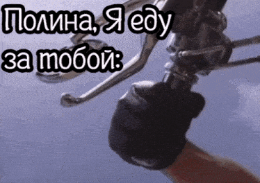 a close up of a person 's hand holding a motorcycle handlebars with russian text behind them