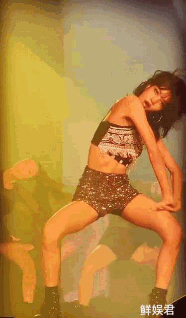 a woman in a crop top and shorts is performing on stage
