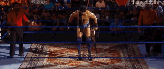 a wrestling ring with a wrestler holding a belt that says wwe