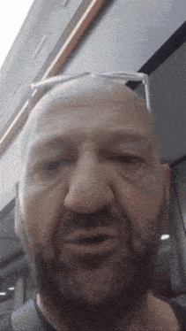 a bald man with a beard wearing sunglasses