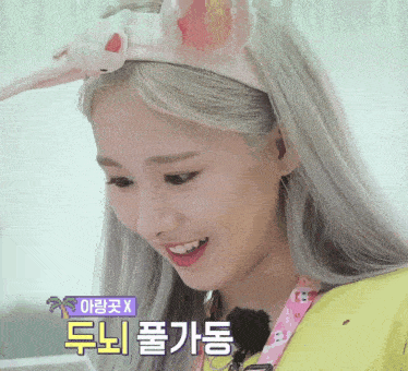 a woman wearing a headband with bunny ears is smiling with a foreign language written below her