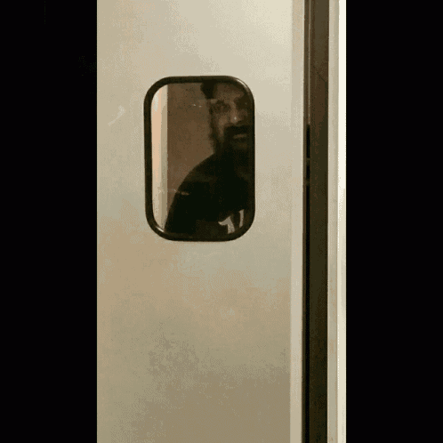a man with a beard is standing in a doorway with the number 11 on the back of his shirt