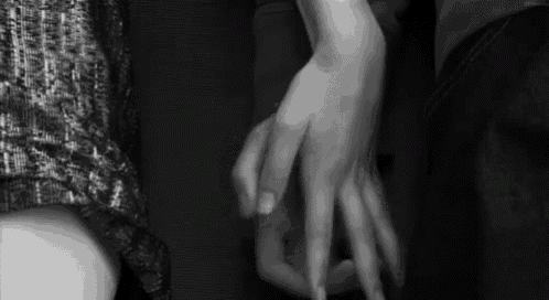 a black and white photo of a couple holding hands .