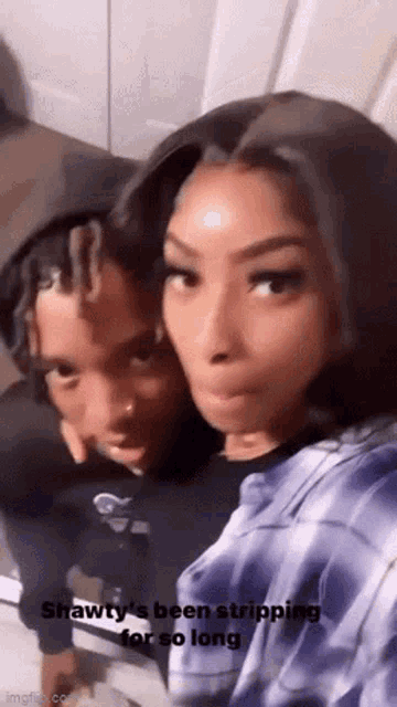 a man and a woman are sitting next to each other on a couch and posing for a picture .