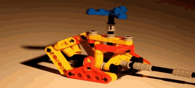 a yellow red and blue lego helicopter with a shadow