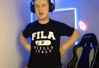 a young man wearing headphones and a fila t-shirt is standing in a room .