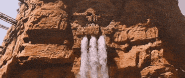 a waterfall is coming out of a rock formation