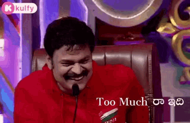 a man with a mustache is laughing in front of a microphone .