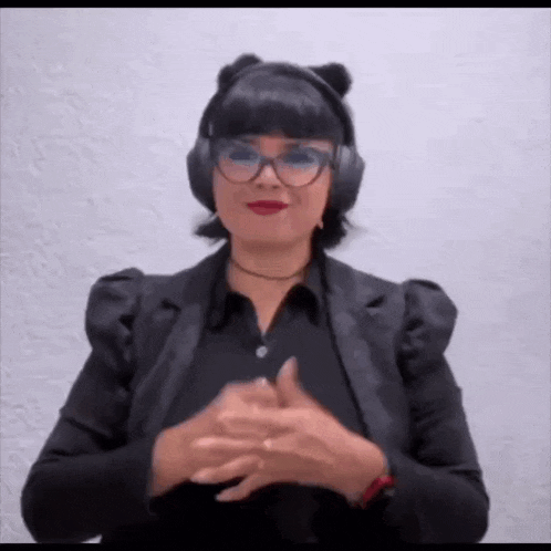 a woman wearing headphones and glasses is making a funny face .