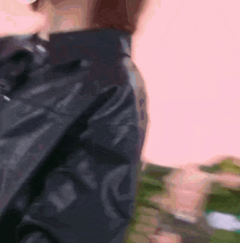 a woman wearing a pink shirt and a black jacket