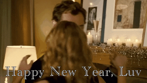 a man and woman hugging with the words happy new year luv behind them