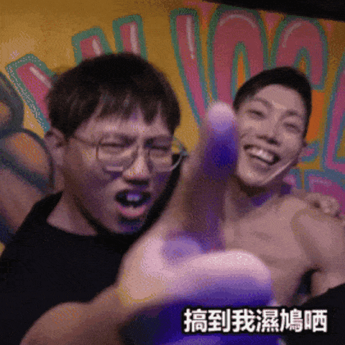 a man with glasses is holding another man 's arm in front of a graffiti wall that says ' cool '