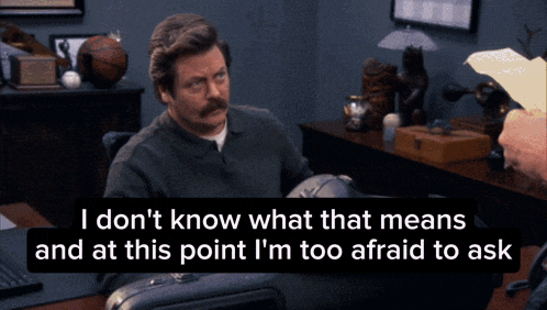 a man with a mustache sits at a desk and says " i don 't know what that means