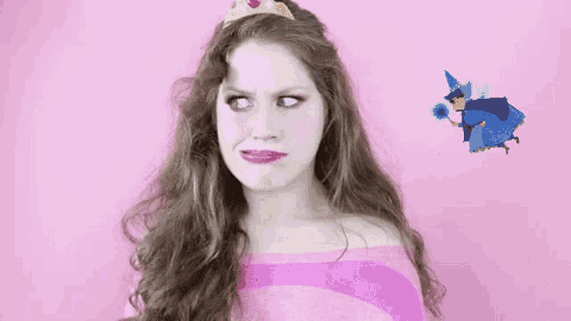 a woman wearing a tiara and a pink striped shirt is making a face .