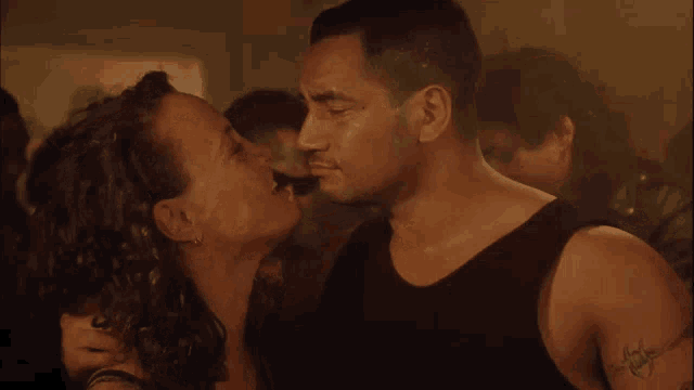 a man with a tattoo on his arm that says ' i love you ' kisses a woman