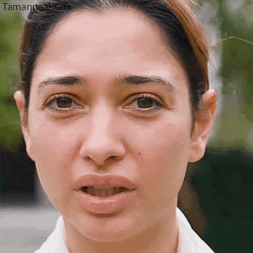 a close up of a woman 's face with her mouth open and a serious look on her face .