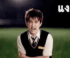 a young man in a black vest and tie is crying