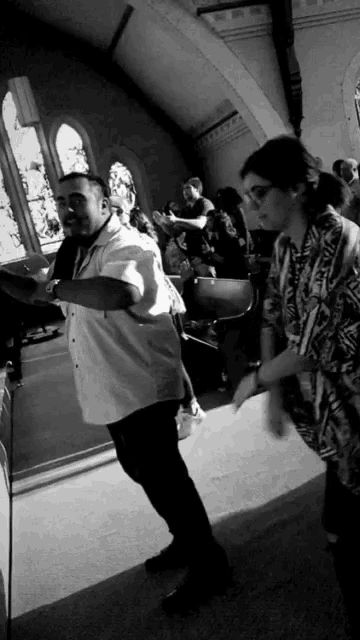 a man in a white shirt is dancing in front of a group of people