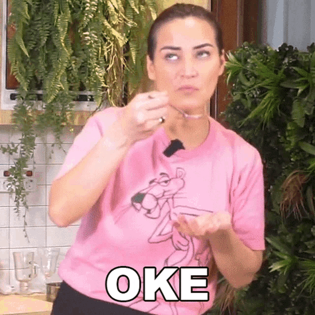 a woman wearing a pink shirt with a pink panther on it says oke