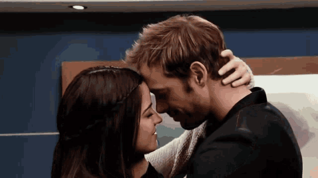 a man and woman are touching their foreheads in a room