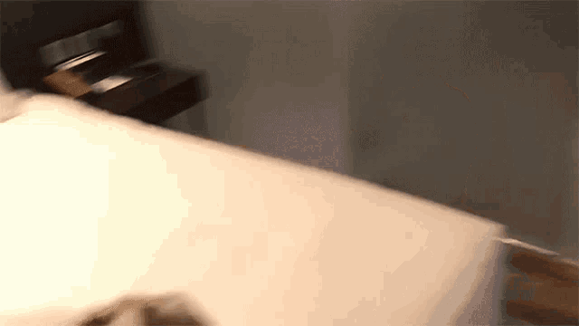 a blurry picture of a bed with a nightstand in the background
