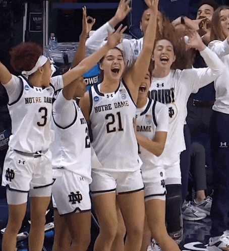 a group of notre dame basketball players celebrate their win