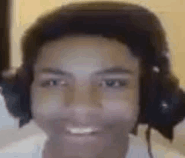 a close up of a man wearing headphones smiling .