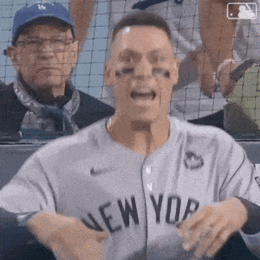 a man in a new york jersey is screaming in the stands