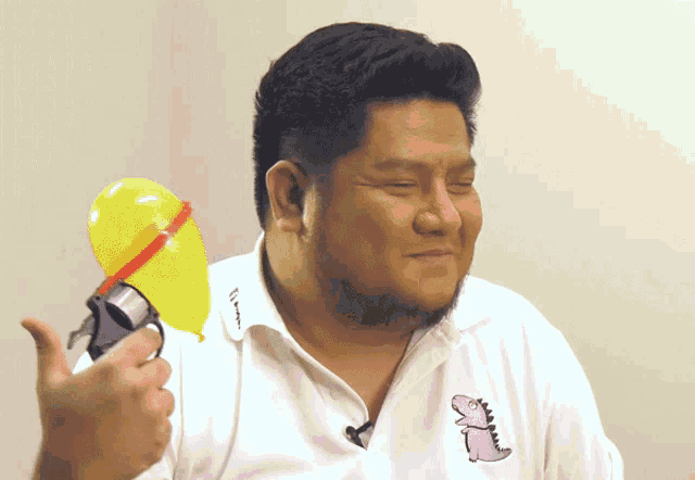 a man wearing a white shirt with a pink dinosaur embroidered on it