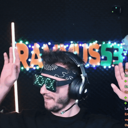 a man wearing headphones and sunglasses is dancing in front of a sign that says rammus