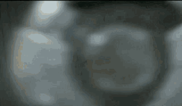 a close up of a person 's face with a sword in their hand .