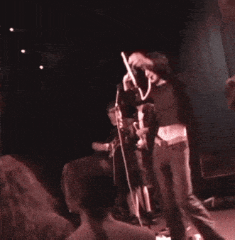 a group of people are standing on a stage playing instruments