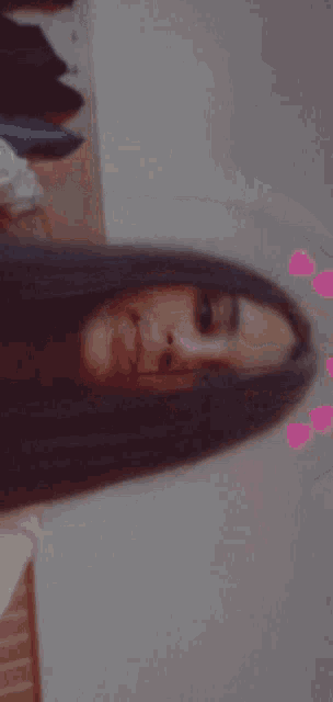 a woman with long hair is laying down with her eyes closed and her mouth open .