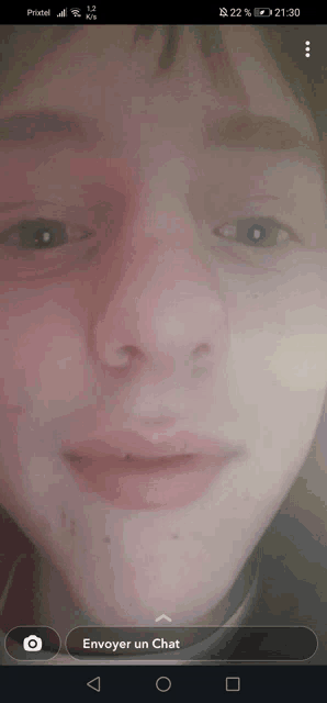a close up of a person 's face on a phone screen that says envoyer un chat