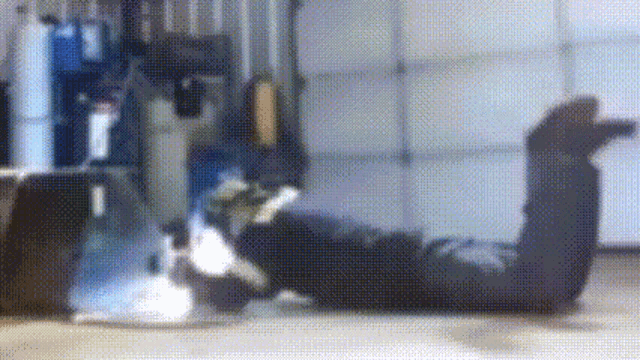 a person is laying on their stomach in a garage .