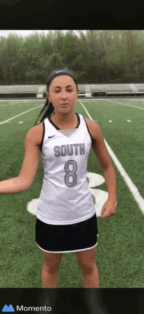 a girl wearing a south 8 jersey is standing on a field