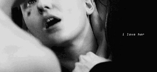 a man is holding a woman 's neck in a black and white photo with the words `` i love her '' .