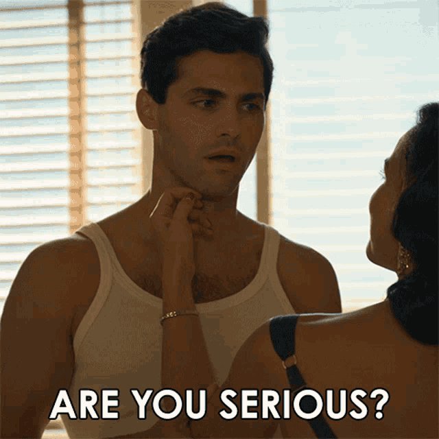 a man in a white tank top is being touched by a woman with the caption " are you serious "